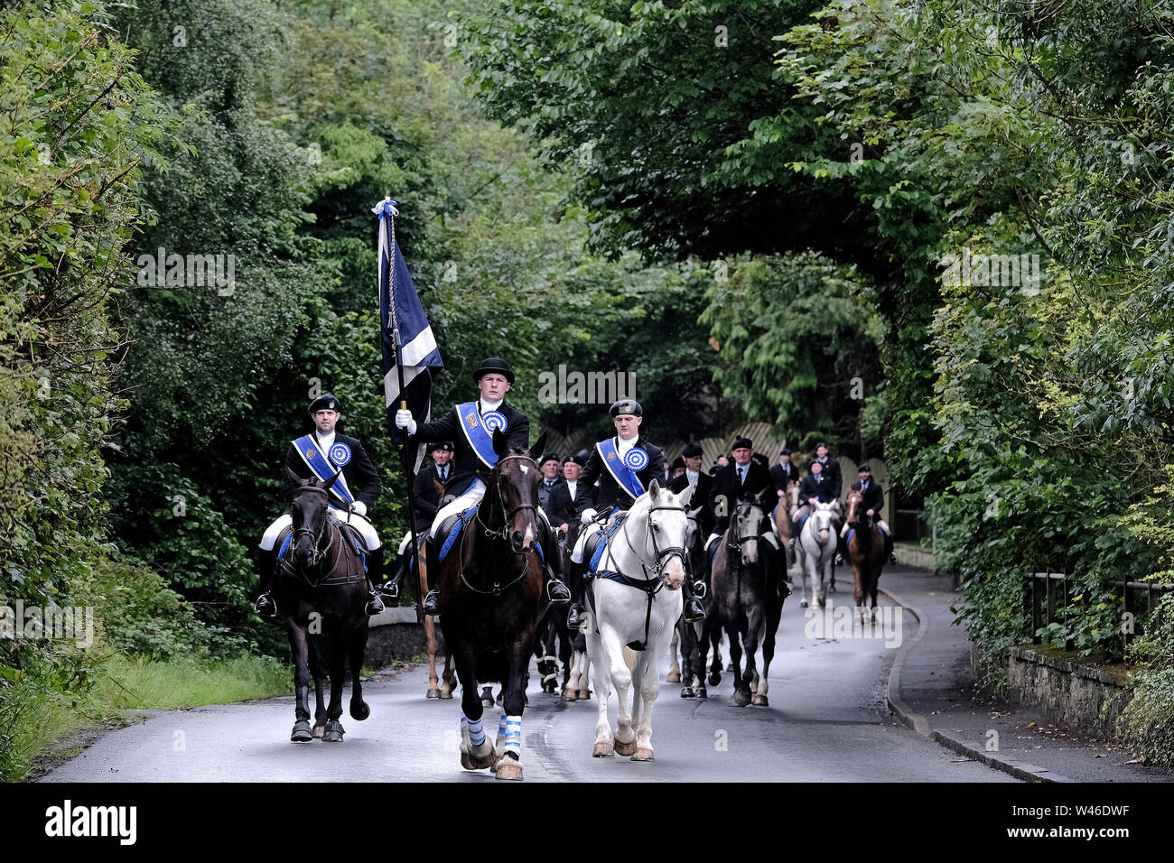 Kelso, Scotland, UK. 20th July 2019.    Kelso Civic Week  - Yetholm Ride out, Kelso. Kelso Laddie Mark Henderson carries the Town Flag (Standard) ahead of the 200 strong mounted cavalcade with RHM Sean Hook (2018 KL), Craig Logan (2017 KL), on the ride out to Yetholm Saturday 20 July 2019.   (Credit: Rob Gray ) Credit: Rob Gray/Alamy Live News Stock Photo