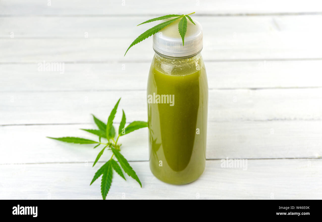 CBD Cannabis Hemp infused smoothie drink with leafs on wooden table Stock Photo