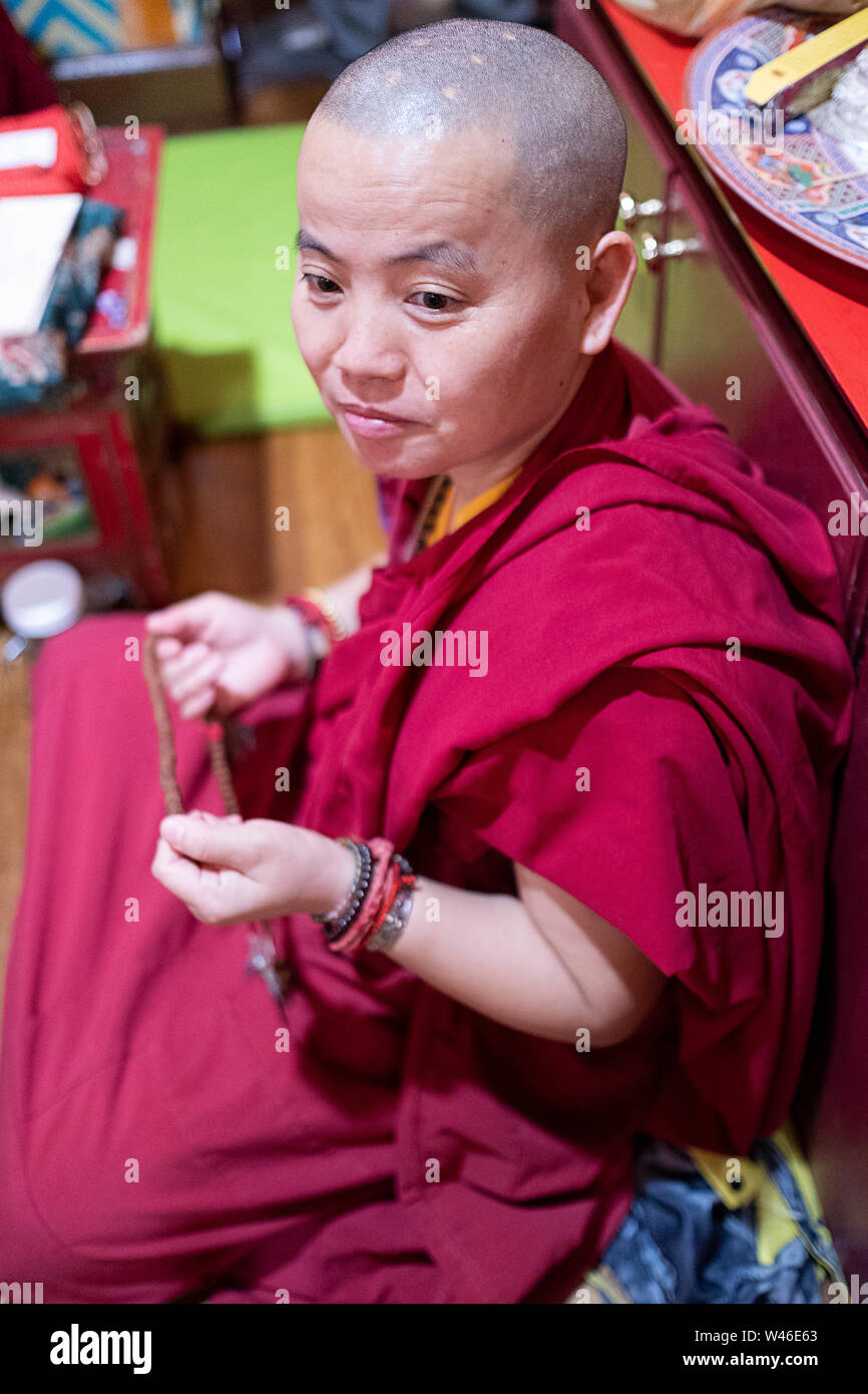 Portrait of a very young looking Nepalese Sherpa Buddhist nun with a shaved head at a temple in Elmhurst Queens, New York. Stock Photo