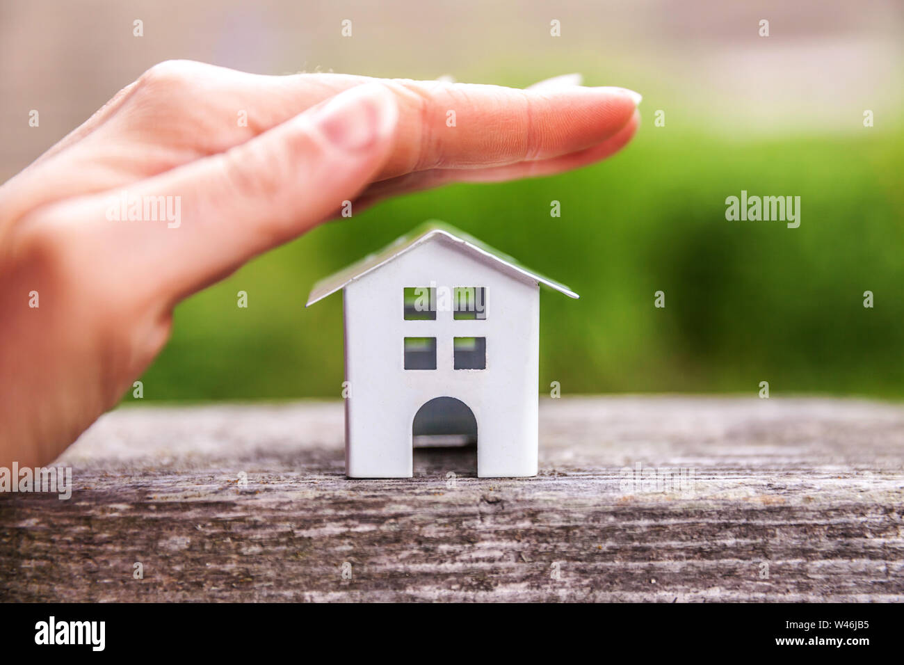 Miniature model house in wooden background near green backdrop and ...