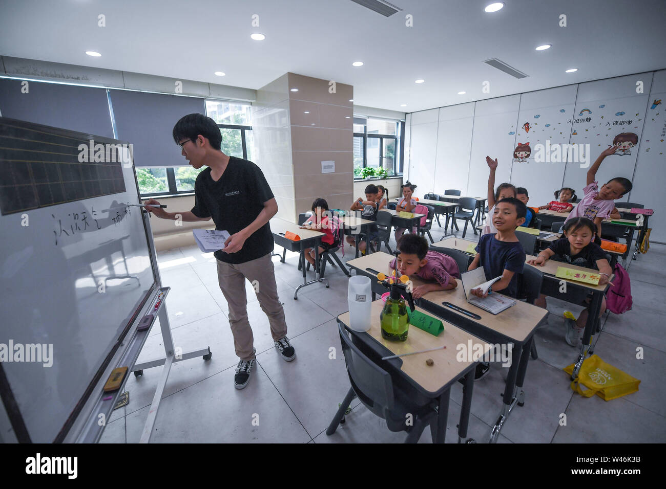 (190720) -- HAINING, July 20, 2019 (Xinhua) -- A science class is given as part of a summer camp organized by a local company for the children of its migrant workers in Haining, east China's Zhejiang Province, July 20, 2019. Running for 40 days starting from mid-July, the summer camp invites 180 children whose parents work for the company away from home and thus offers them a chance for family reunion. Besides, the children can expect an enriched summer life here by taking academic, etiquette and sports courses given by university volunteer tutors. (Xinhua/Xu Yu) Stock Photo