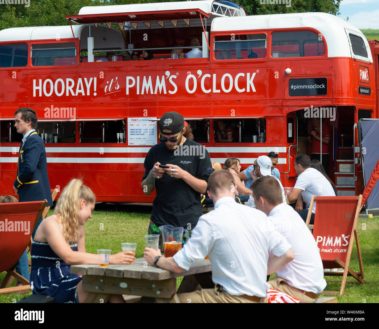 People enjoying a Pimms alongside the River Thames  at the Henley Royal Regatta (2019) Henley-on-Thames, England, UK Stock Photo