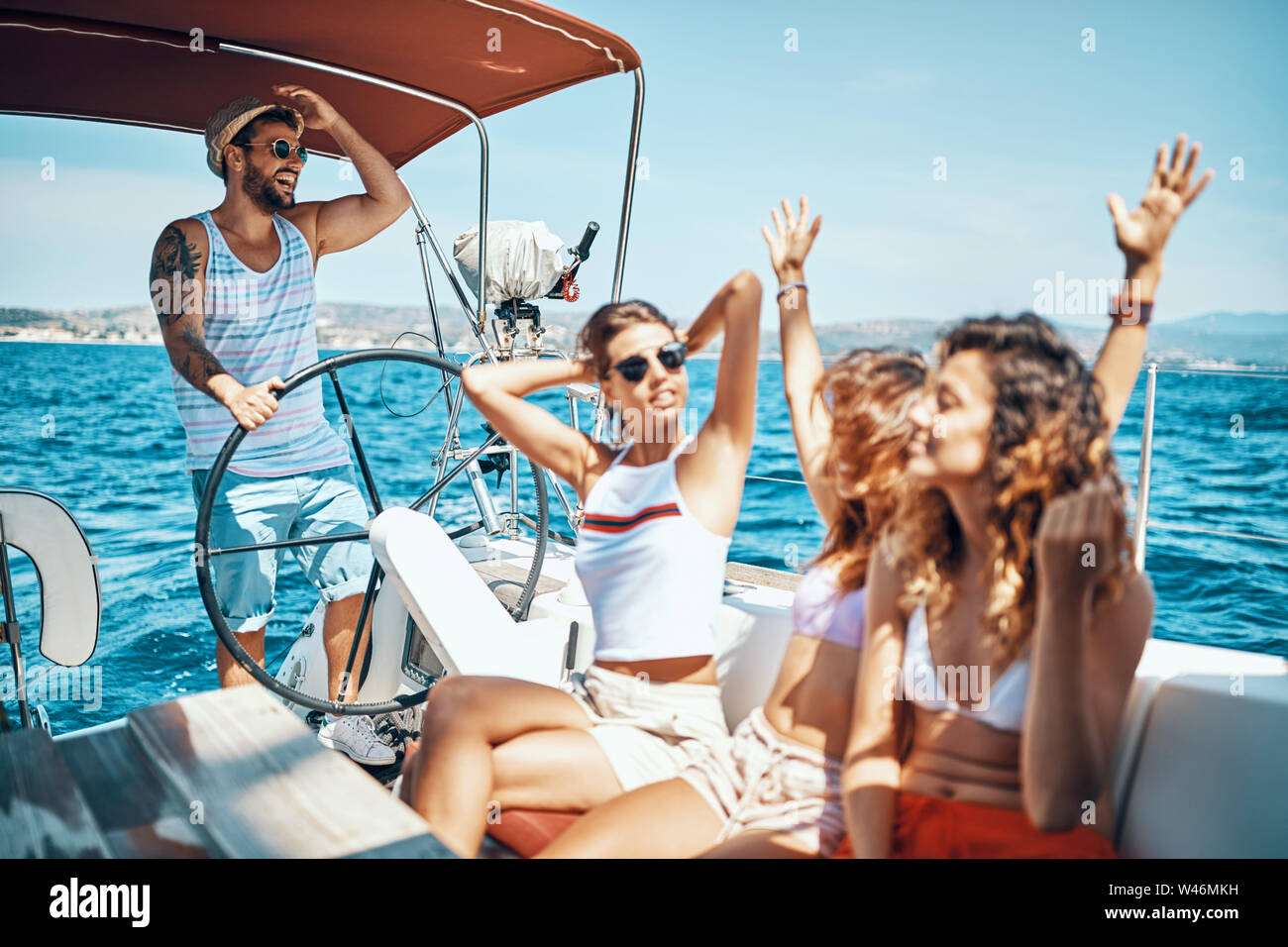 Happy friends having fun on a boat trip in the summer Stock Photo