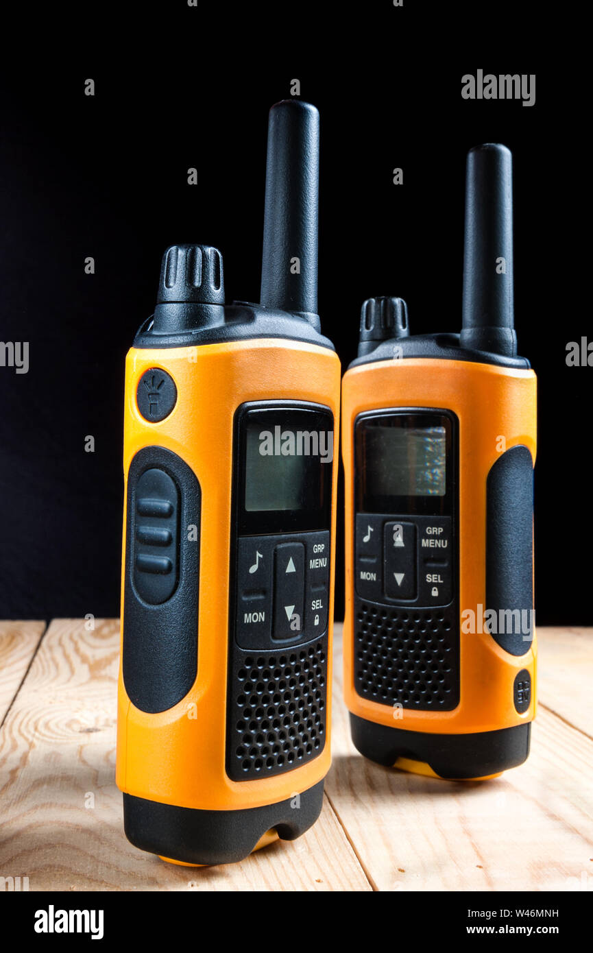 two walkie talkie on wooden table on dark background Stock Photo