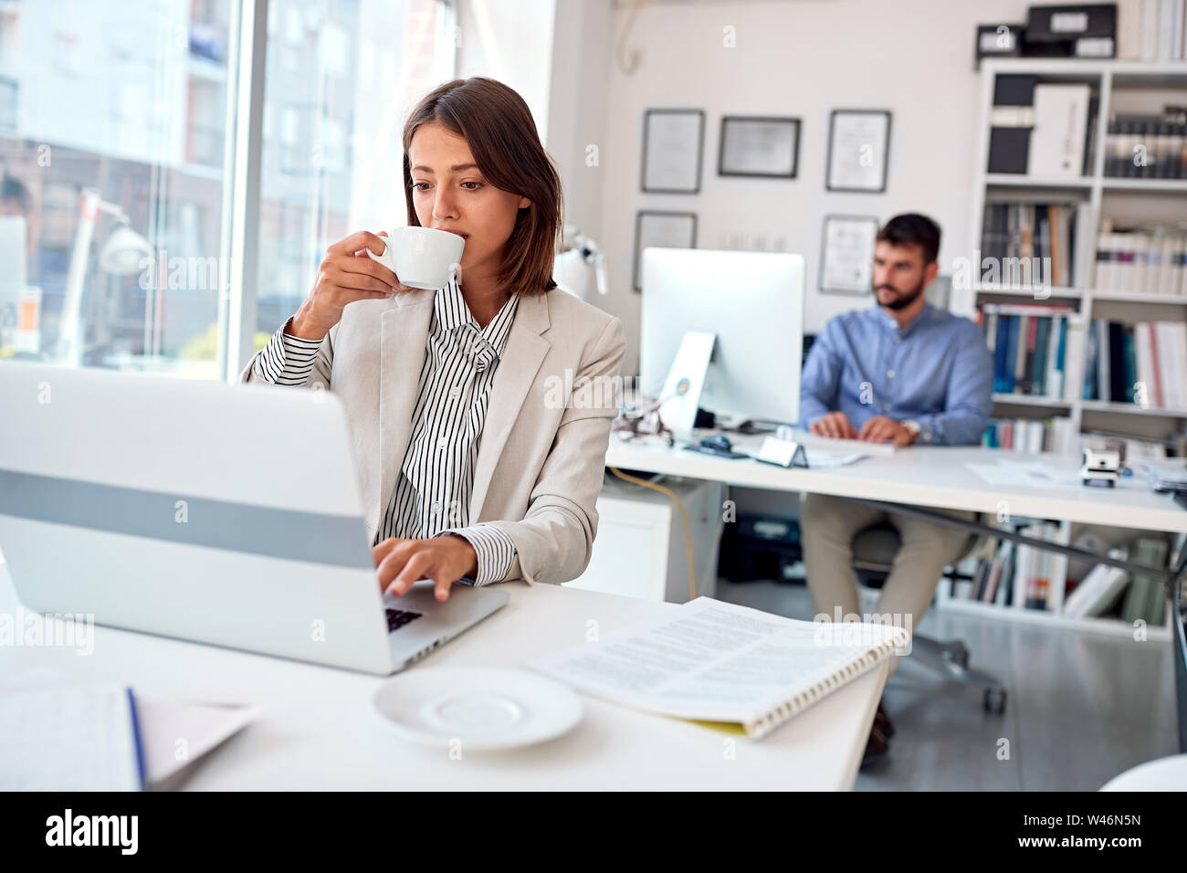 Business young woman drink coffee at work Stock Photo - Alamy
