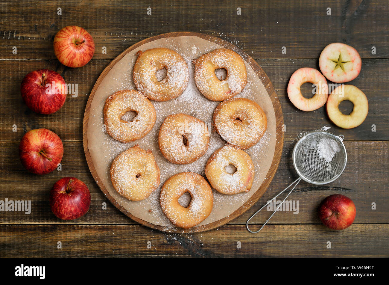 Apple rings and fresh apples on wooden table, top view Stock Photo