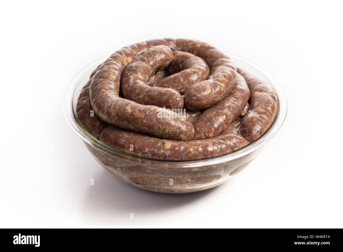 Homemade stuffed pork sausages in a glass bowl isolated on a white