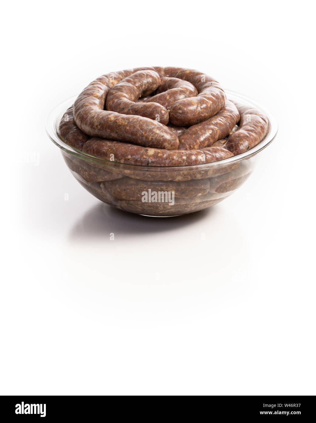 Homemade stuffed pork sausages in a glass bowl isolated on a white