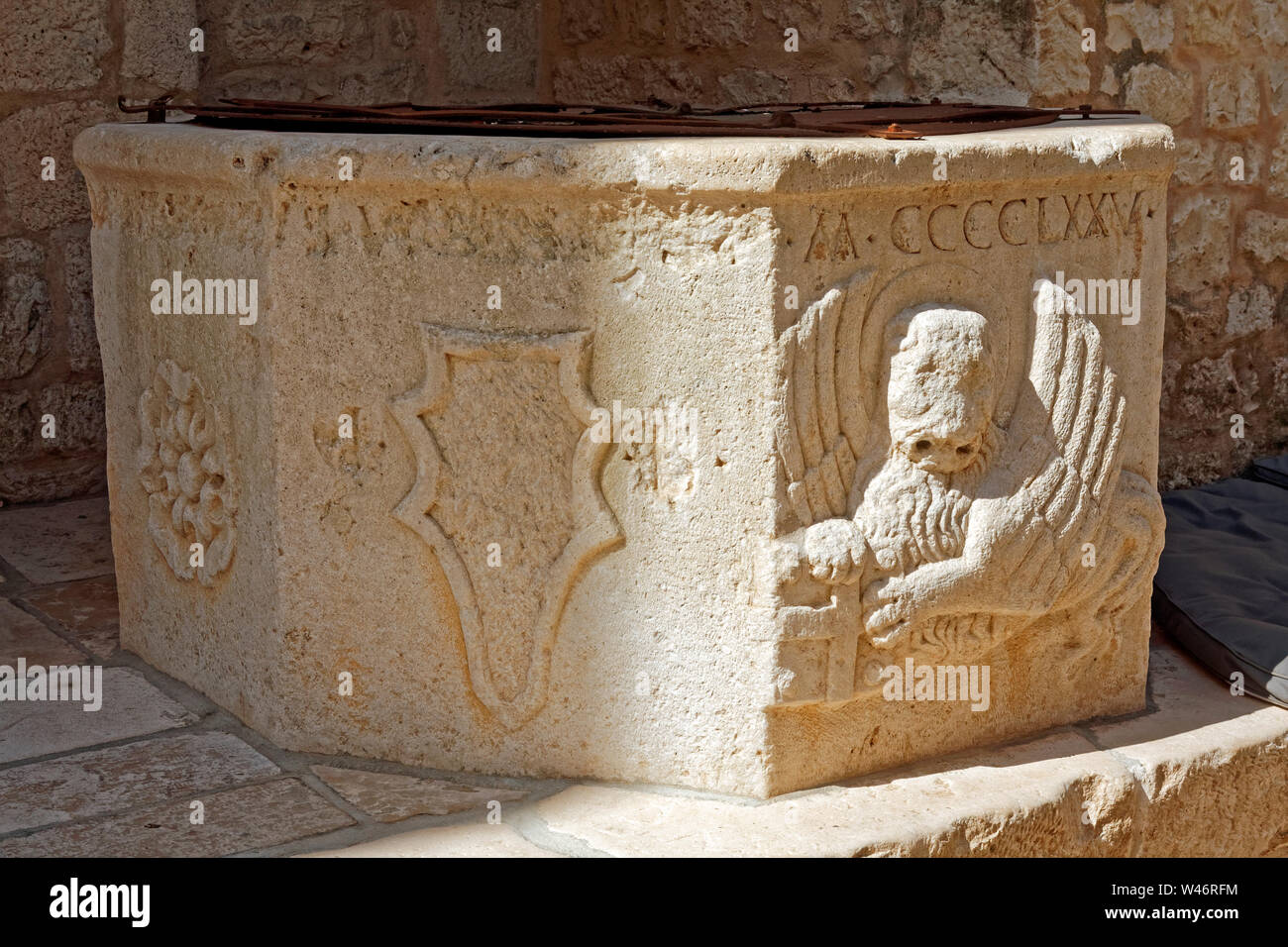 historic old stone well; 475 in Roman numerals, Hvar Town; Croatia; Europe; summer, horizontal Stock Photo