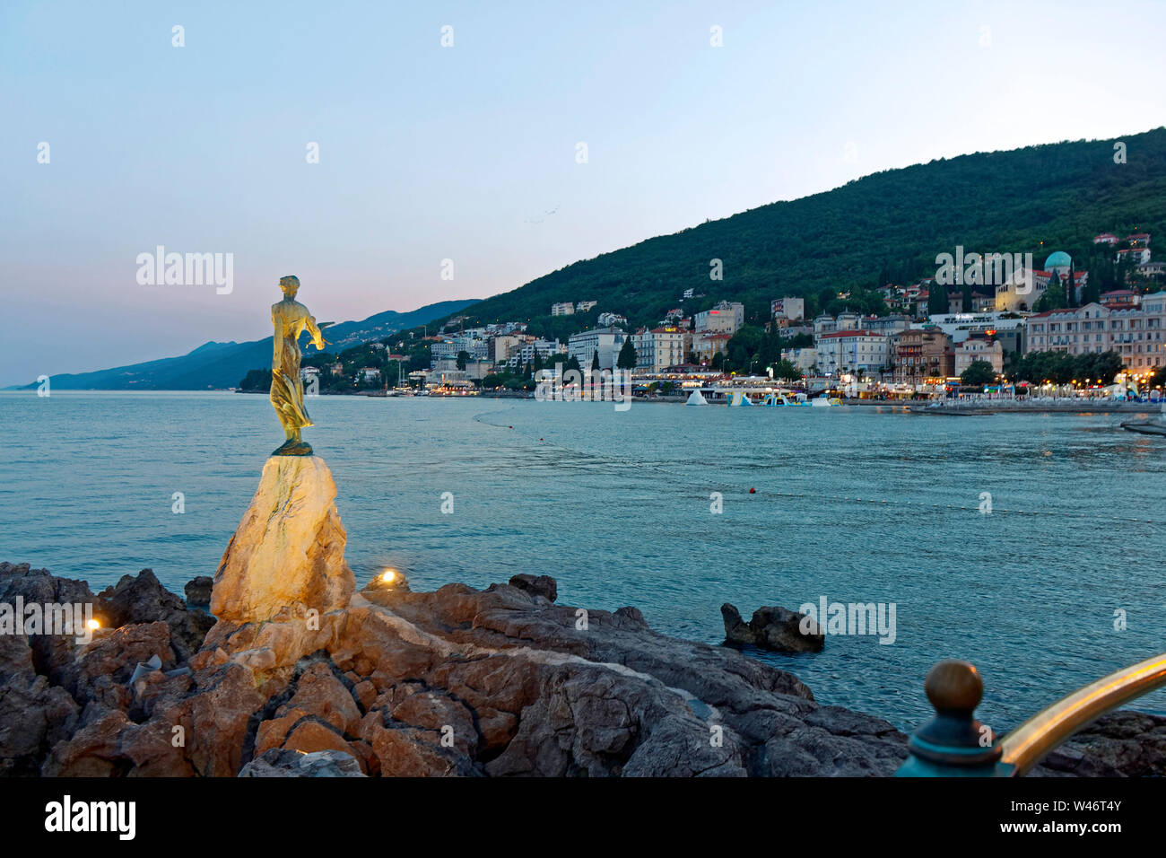 Maiden with Seqgull statue lighted, Adriatic Sea; Lungomare promenade; dusk; hotels, water, Opatija; Croatia; Europe; summer, horizontal Stock Photo