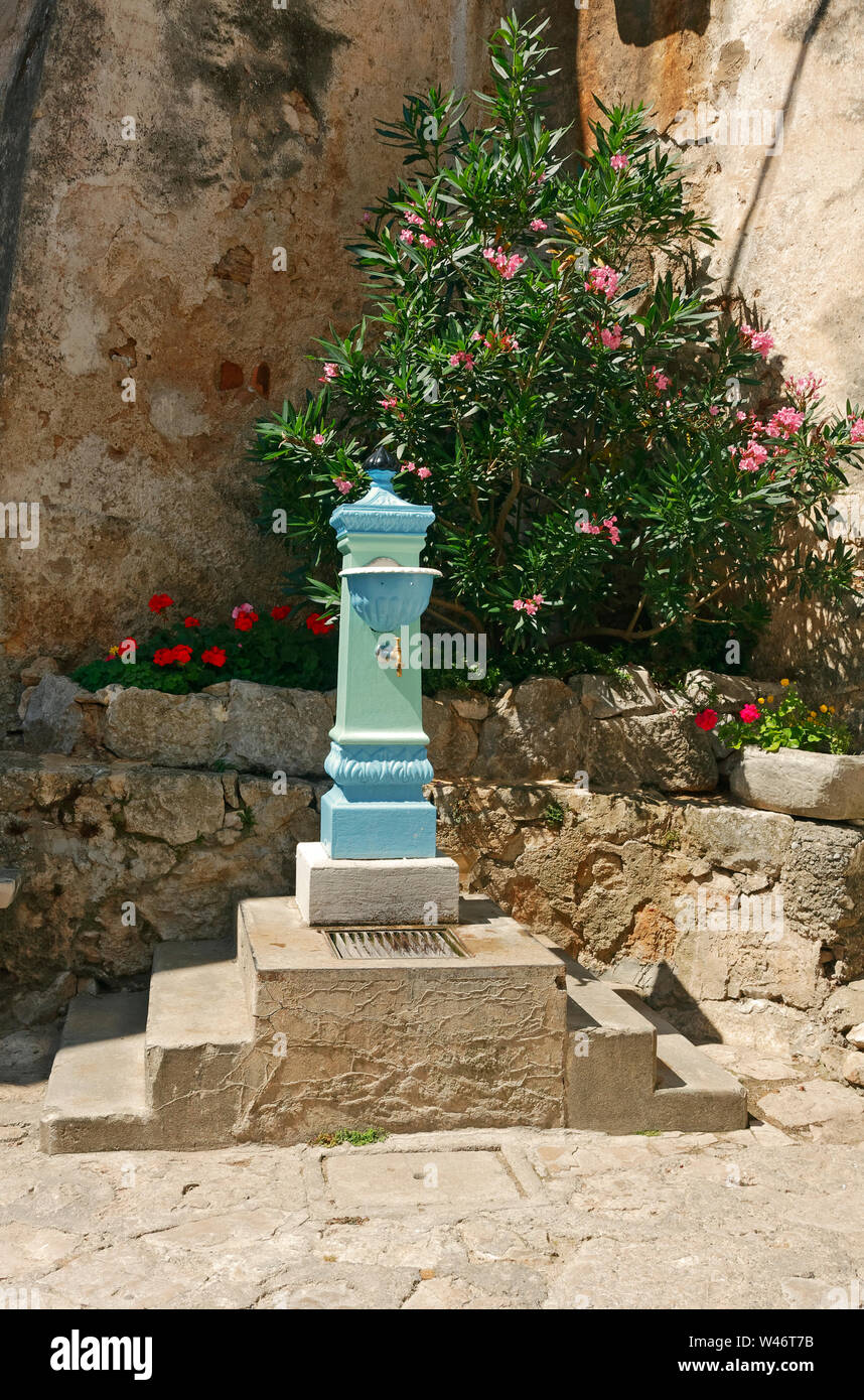 old water fountain; hilltop village; stone wall, flowering shrub