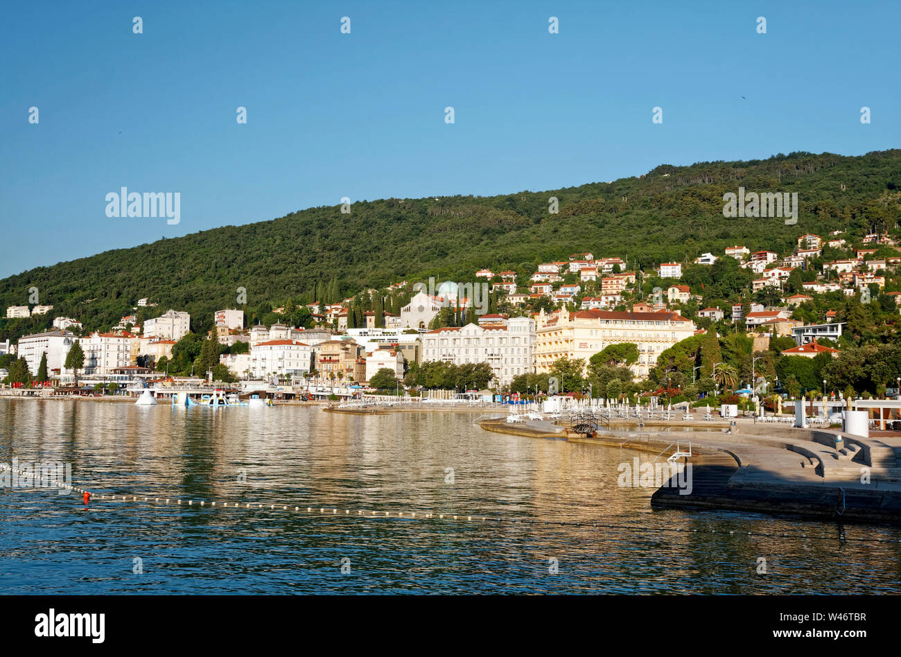 waterfront scene; coastline, hotels, buildings, water recreation, concrete beaches, vacation spot, Lungomare; promenade; Adriatic Sea; Opatija; Croati Stock Photo