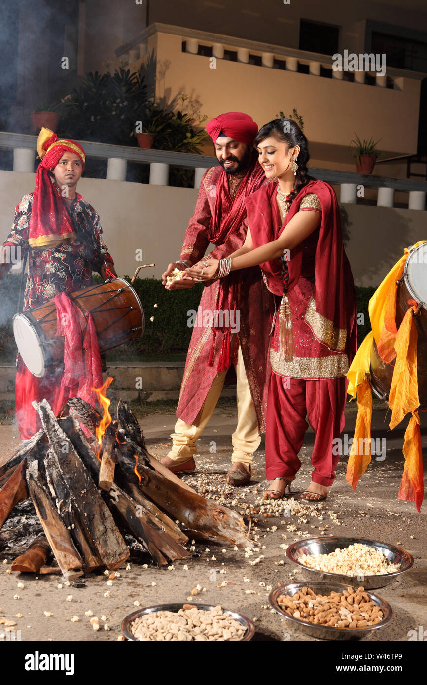 Indian couple celebrating Lohri festival, Punjab, India Stock Photo