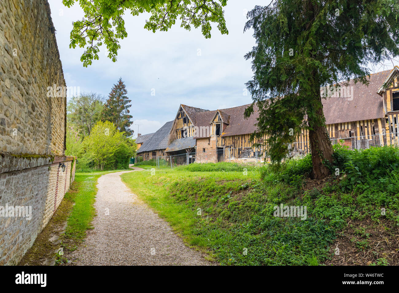 Saint Germain de Livet Château   wall with half timbered house in the background, France Stock Photo