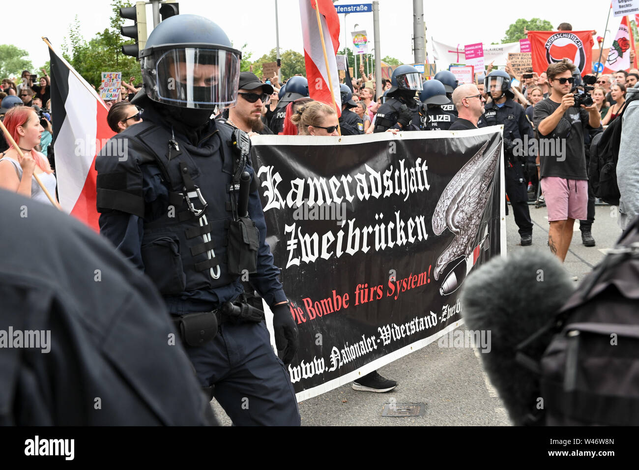 Hanover, Germany. Kassel, Germany. 20th July, 2019. Supporters of the right-wing extremist mini-party 'Die Rechte' pass by counter-demonstrators during their demonstration. The party had called for a demonstration in Kassel against media prejudgement in connection with the Lübcke case. A massive police presence is to prevent possible riots between the two camps. Credit: Uwe Zucchi/dpa/Alamy Live News Stock Photo
