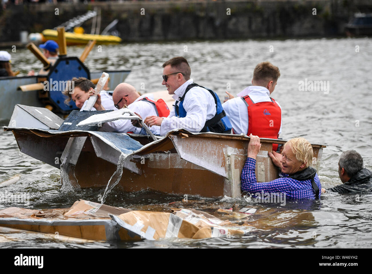 Boats begin to sink in the cardboard boat race as people cling on ...