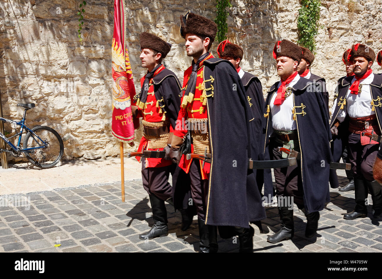 Cravat Regiment Guard of Honor, Kravat, men walking, old style Croat uniforms, ceremonial; cobblestone street, old city wall, Zagreb; Croatia; Europe; Stock Photo