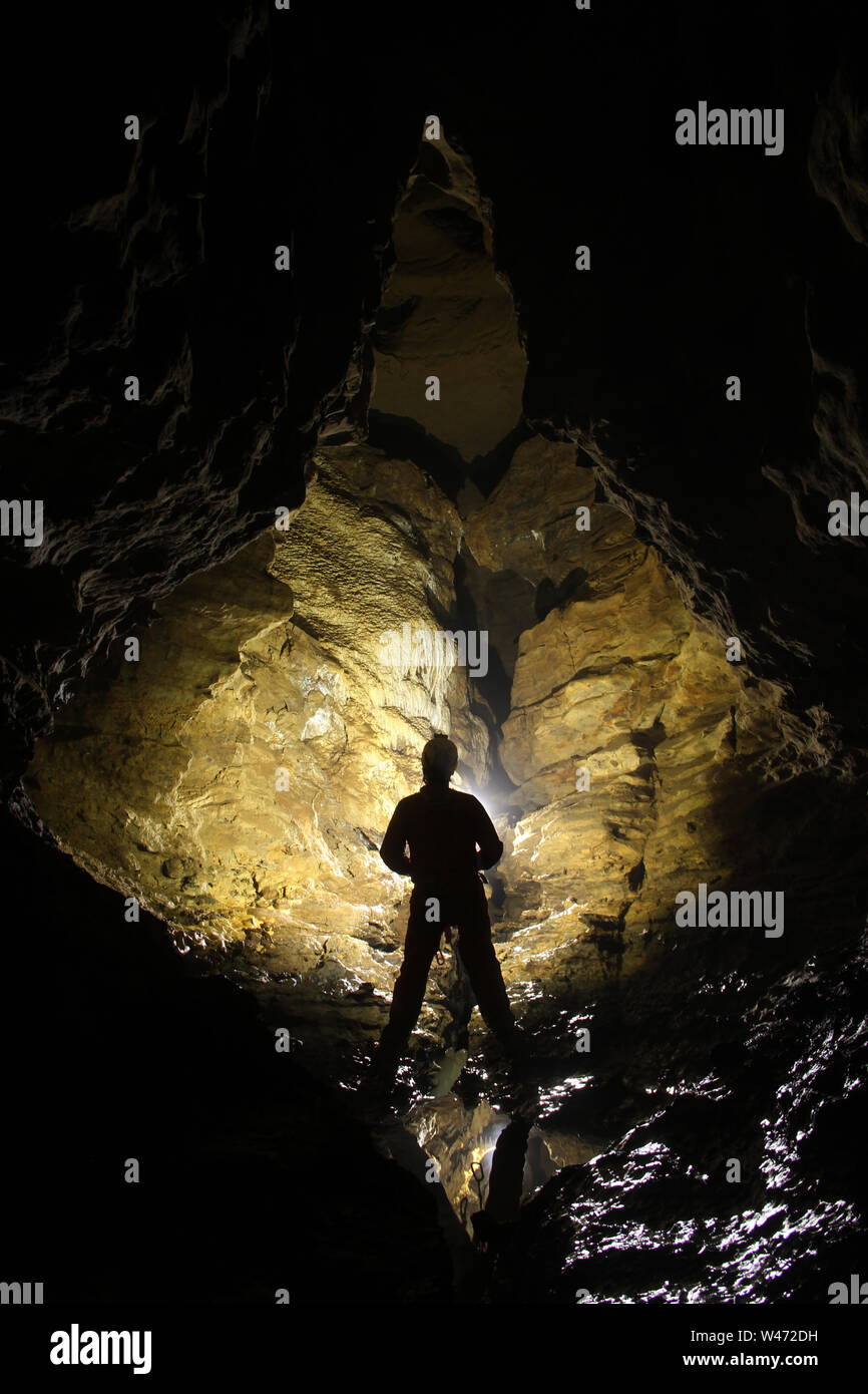 Caver exploring a cave Stock Photo
