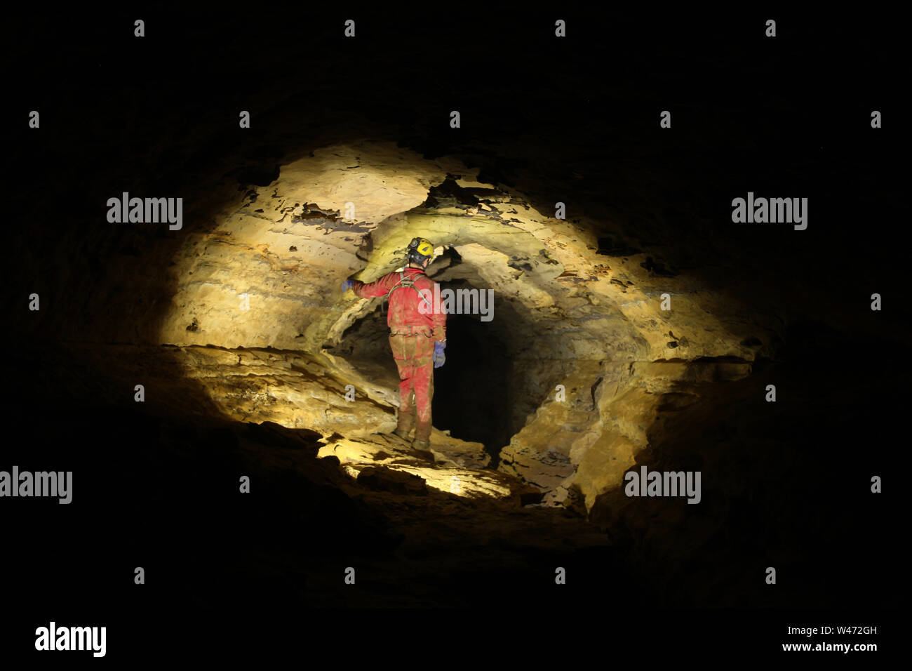 Caver exploring a cave Stock Photo