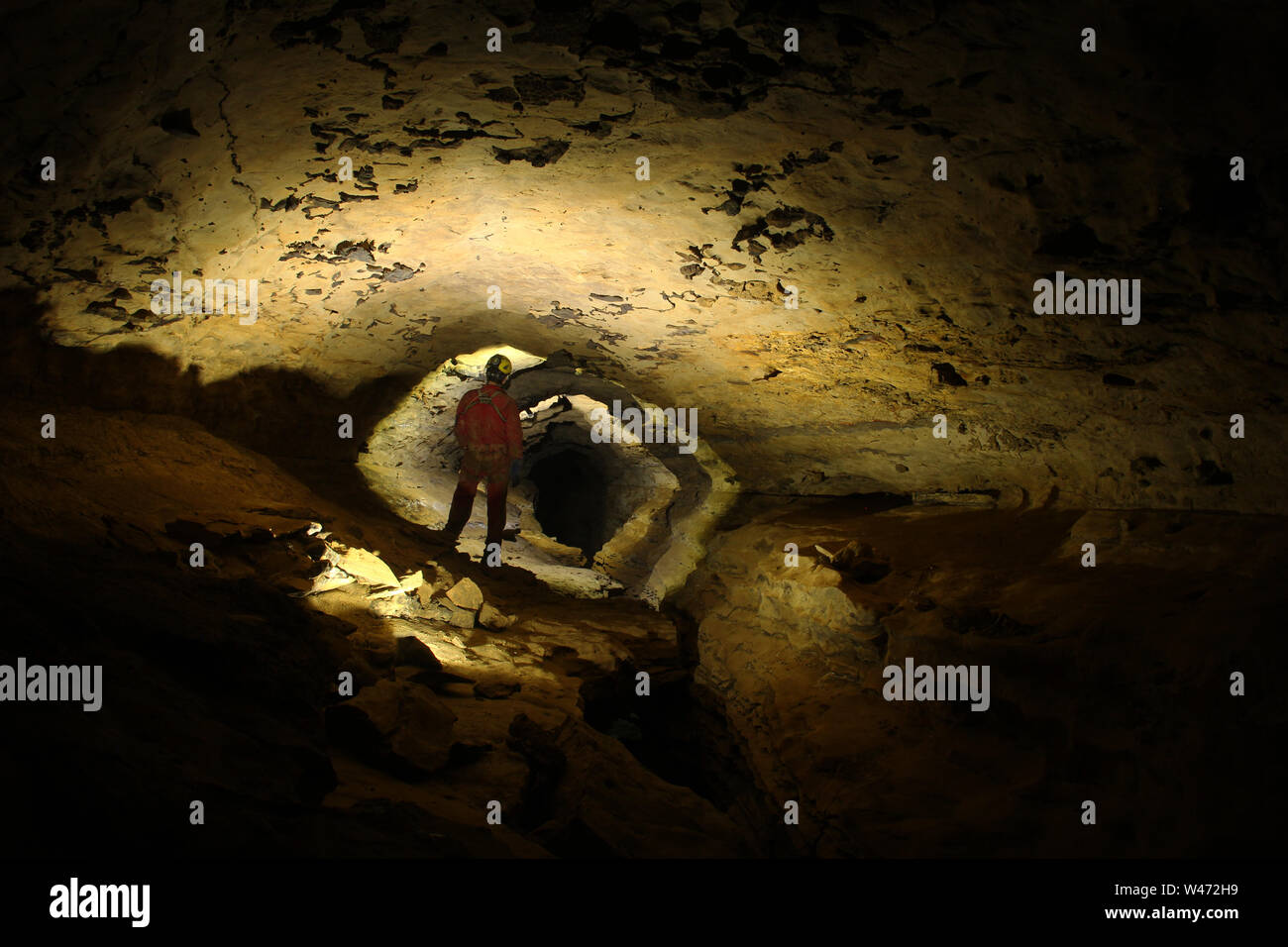 Caver exploring a cave Stock Photo - Alamy
