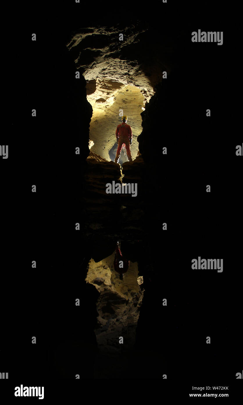 Caver exploring a cave Stock Photo - Alamy