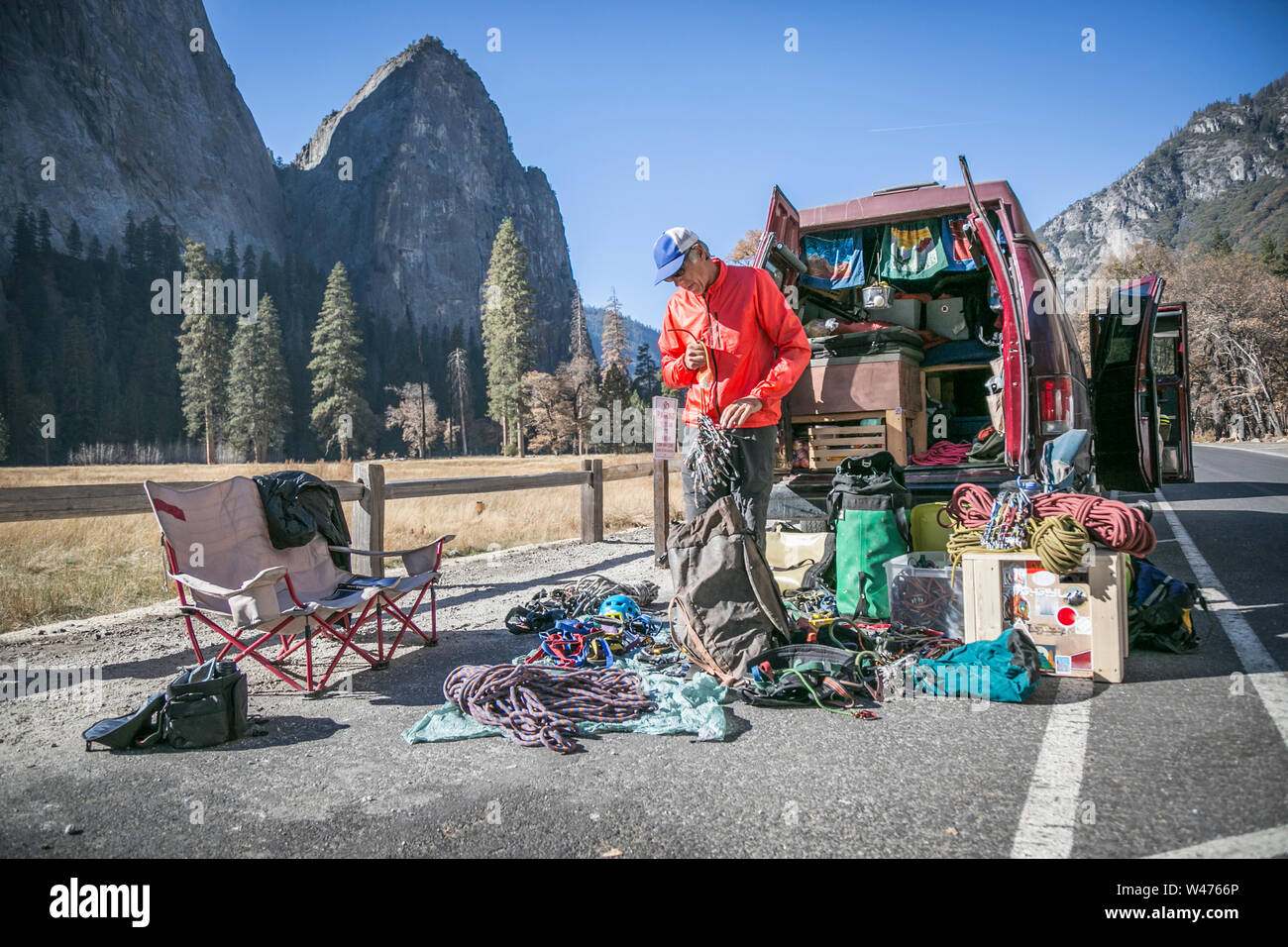 A climber sorts gear behind his van in El Capitan meadows Stock Photo