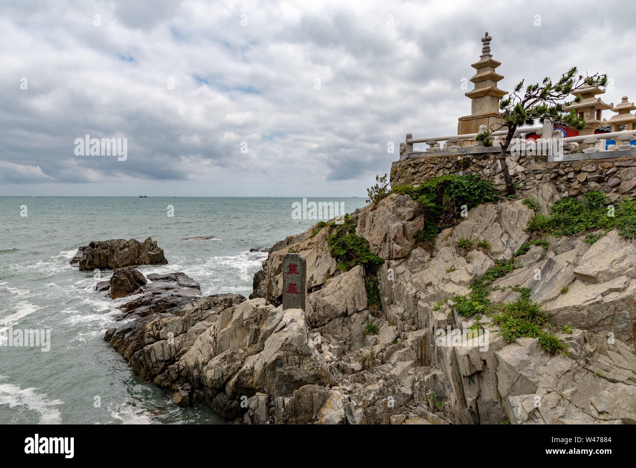BUSAN, SOUTH KOREA - JUNE 9, 2019: One pagoda facing the sea at Yonggungsa temple on a cloudy summer afternoon Stock Photo