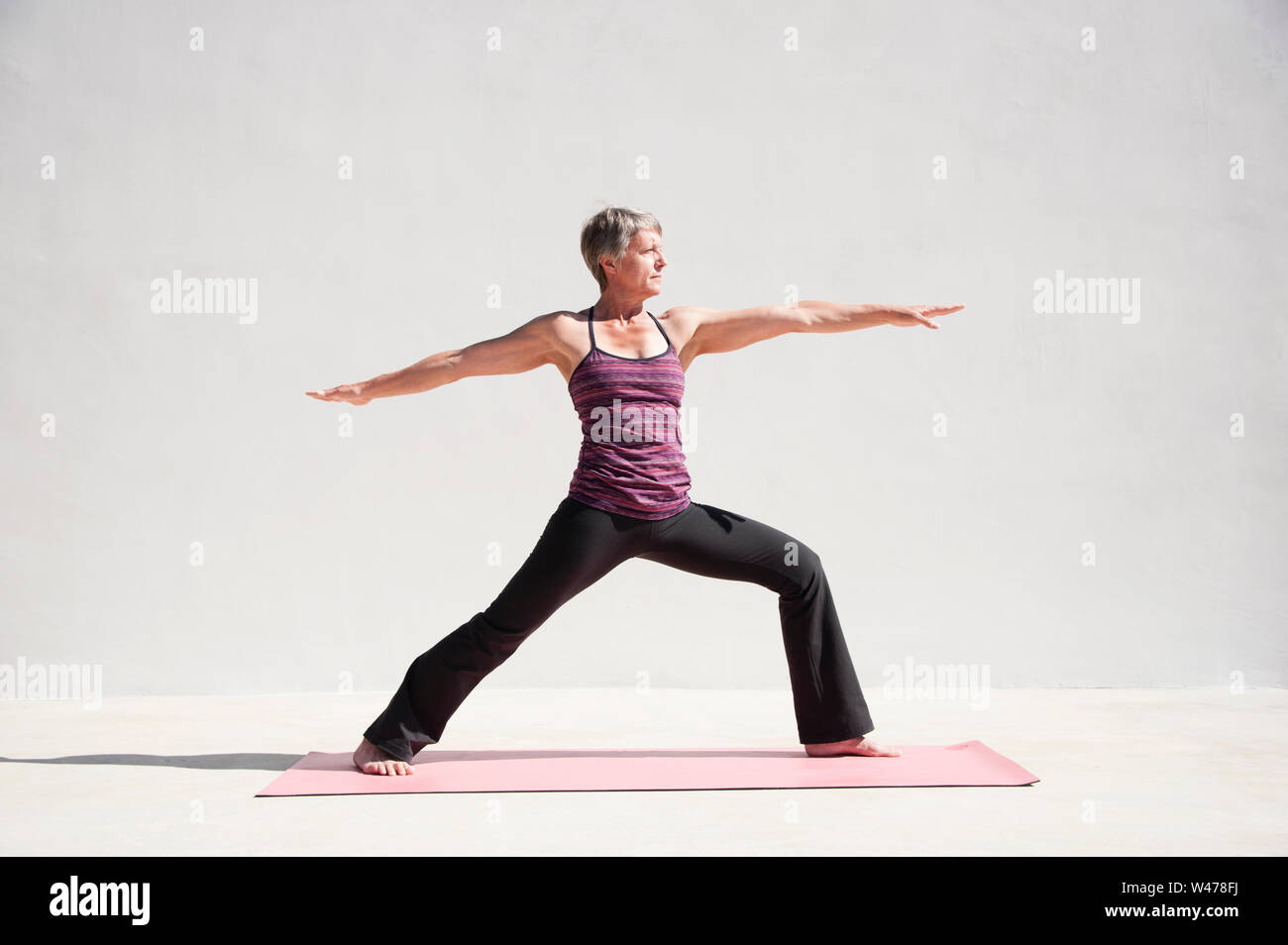 Mature senior woman practing gentle restorative yoga poses Mature senior woman practing gentle restorative yoga poses