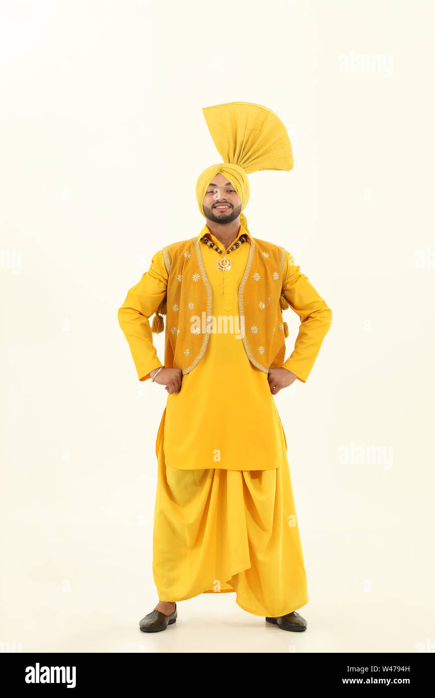 Man standing with his arms akimbo and smiling Stock Photo - Alamy