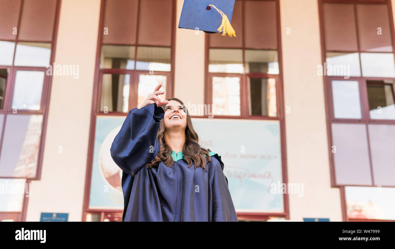 University graduates throwing graduation hats in the air. Group of ...