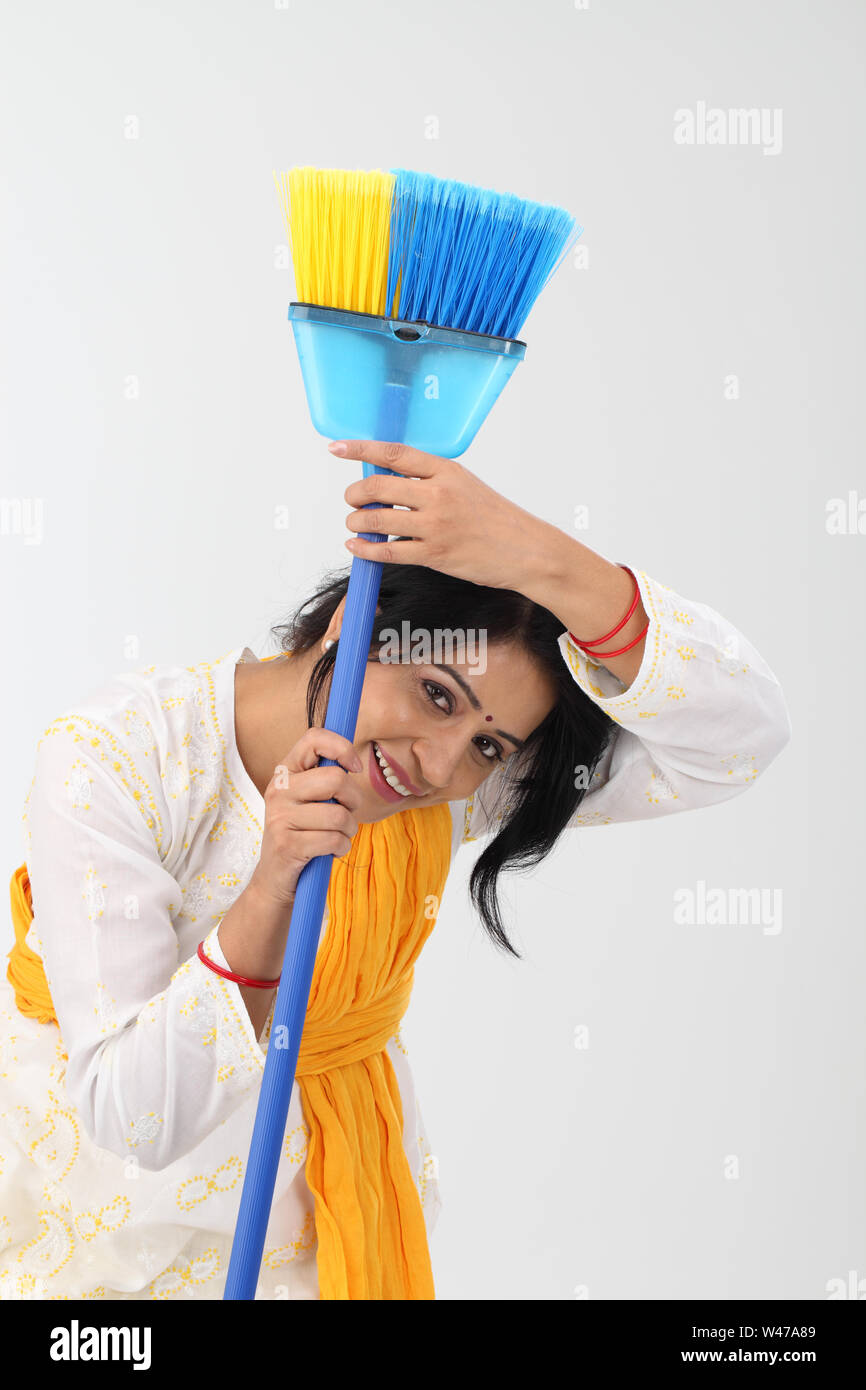 Indian woman holding broom and smiling Stock Photo Alamy