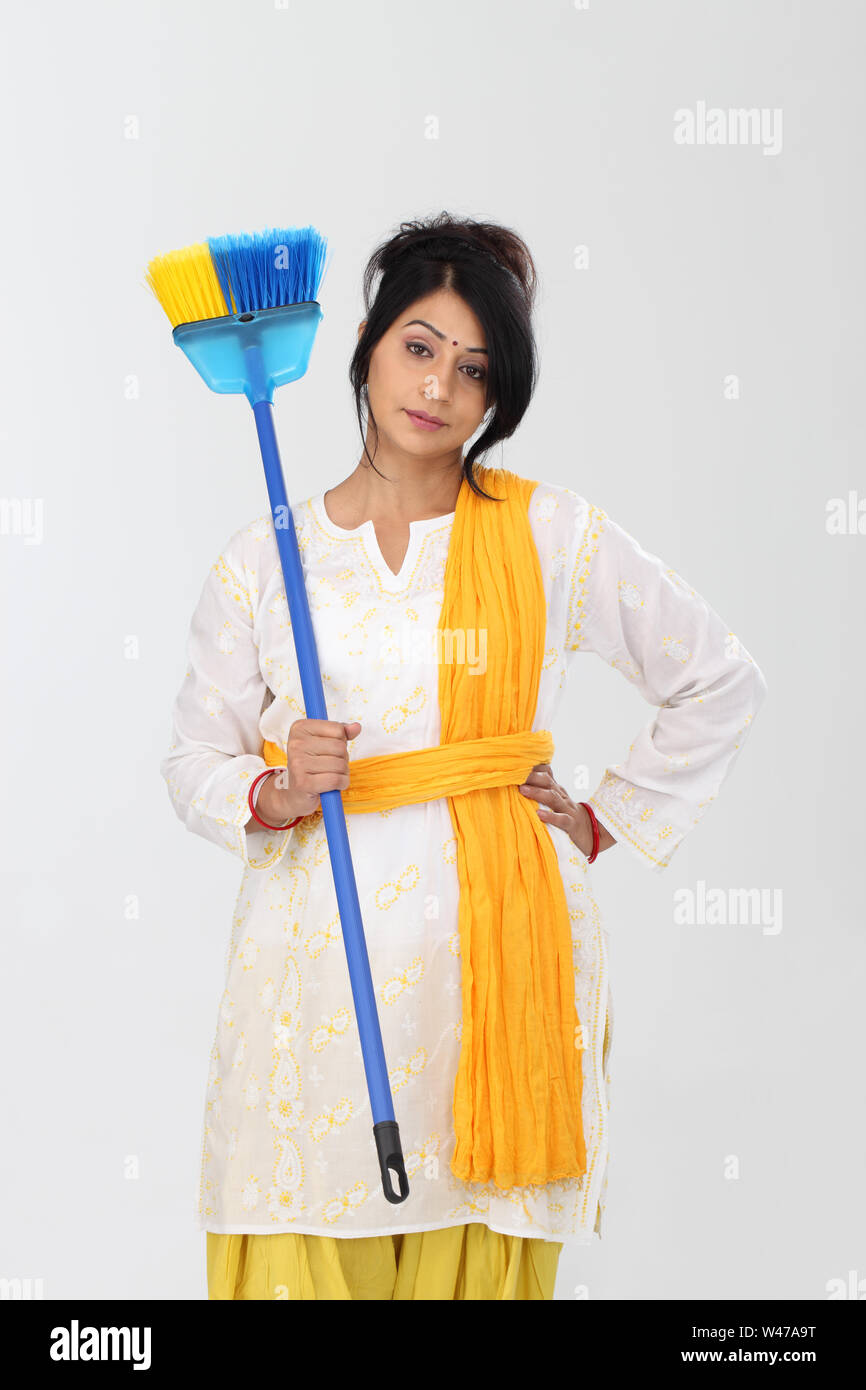 Woman holding broom with her hand on hip Stock Photo Alamy