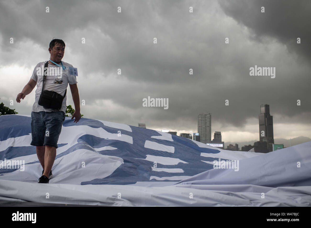 A man prepares a banner with message during pro-government  Safeguard Hong Kong rally at Tamar Park.Government supporters show up in number of tens of thousands in a pro-police rally, at Tamar Park.  Named Safeguard Hong Kong,  the demonstration was co-organized by 70 pro-Beijing figures and  was attended by local residents, mainland immigrants, members of ethnic minorities, as well as visitors from across the border. Stock Photo