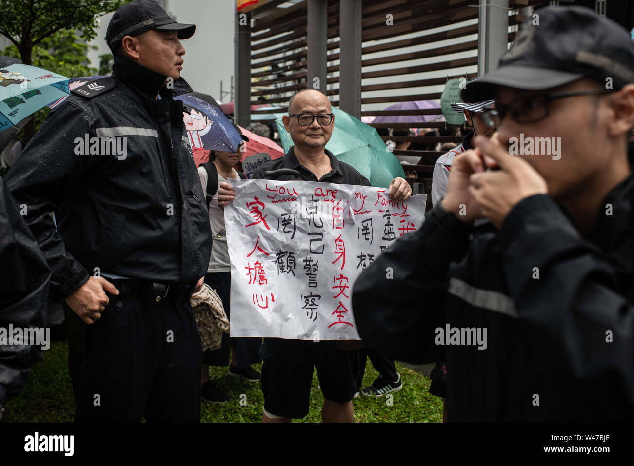 A man receives protection from a group of policemen after been lashed because of his poster with a supportive message to the police.Government supporters show up in number of tens of thousands in a pro-police rally, at Tamar Park.  Named Safeguard Hong Kong,  the demonstration was co-organized by 70 pro-Beijing figures and  was attended by local residents, mainland immigrants, members of ethnic minorities, as well as visitors from across the border. Stock Photo