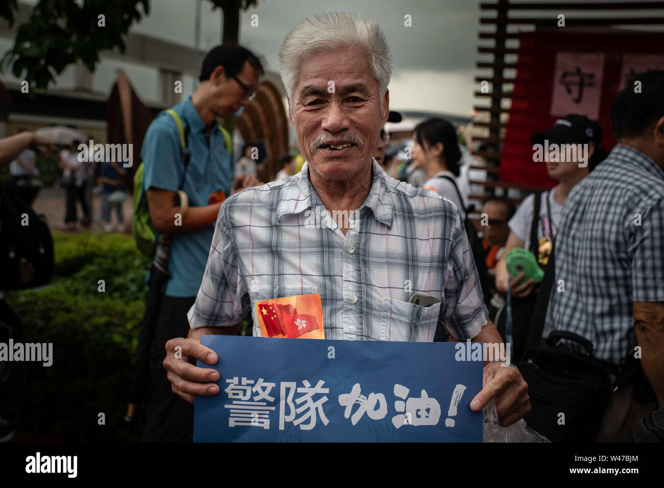 A man holding a placard with message while participating of pro-government Safeguard Hong Kong rally at Tamar Park.Government supporters show up in number of tens of thousands in a pro-police rally, at Tamar Park.  Named Safeguard Hong Kong,  the demonstration was co-organized by 70 pro-Beijing figures and  was attended by local residents, mainland immigrants, members of ethnic minorities, as well as visitors from across the border. Stock Photo