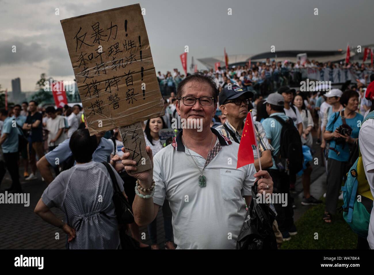 A man holding a placard with message while participating of pro-government Safeguard Hong Kong rally at Tamar Park.Government supporters show up in number of tens of thousands in a pro-police rally, at Tamar Park.  Named Safeguard Hong Kong,  the demonstration was co-organized by 70 pro-Beijing figures and  was attended by local residents, mainland immigrants, members of ethnic minorities, as well as visitors from across the border. Stock Photo