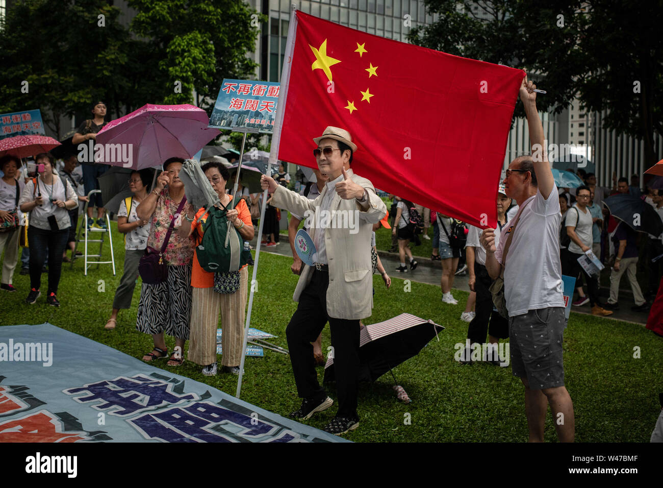 Pro-government supporters posing with a Chinese flag at the Safeguard Hong Kong rally at Tamar Park.Government supporters show up in number of tens of thousands in a pro-police rally, at Tamar Park.  Named Safeguard Hong Kong,  the demonstration was co-organized by 70 pro-Beijing figures and  was attended by local residents, mainland immigrants, members of ethnic minorities, as well as visitors from across the border. Stock Photo