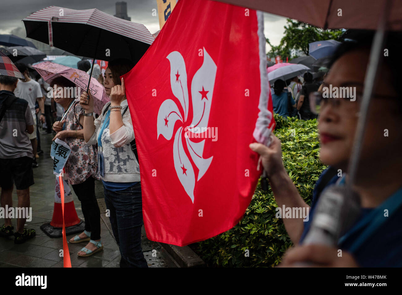 Pro-government supporters holding a Hong Kong flag at the Safeguard Hong Kong rally at Tamar Park.Government supporters show up in number of tens of thousands in a pro-police rally, at Tamar Park.  Named Safeguard Hong Kong,  the demonstration was co-organized by 70 pro-Beijing figures and  was attended by local residents, mainland immigrants, members of ethnic minorities, as well as visitors from across the border. Stock Photo
