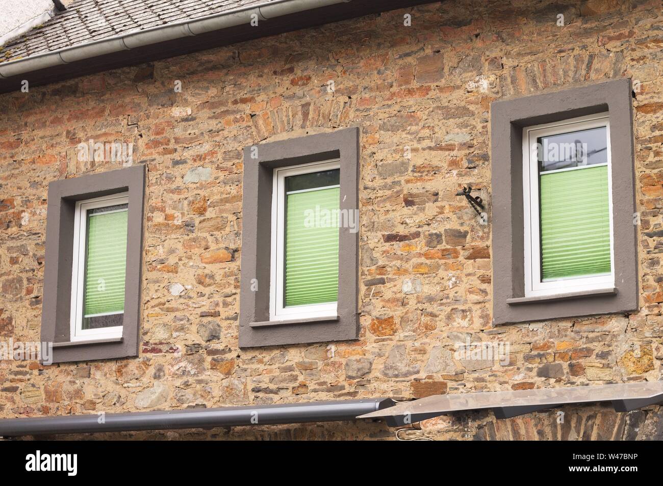 Three windows with green shutters in a brick wall (Germany, Europe