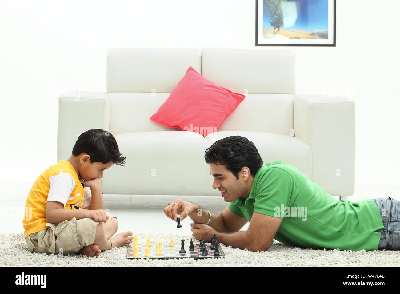 Man with his son playing chess at home Stock Photo
