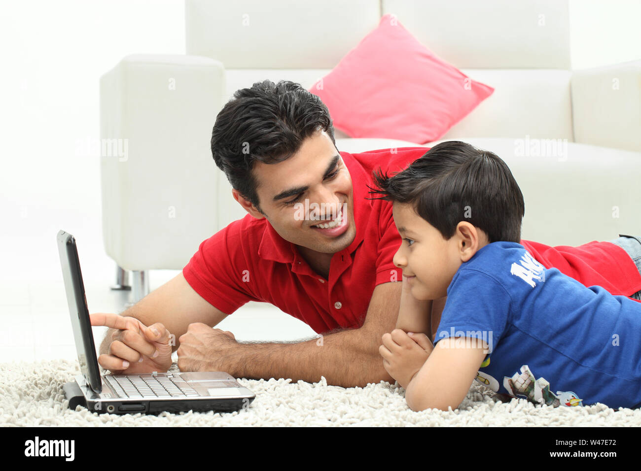 Man assisting his son in using laptop Stock Photo