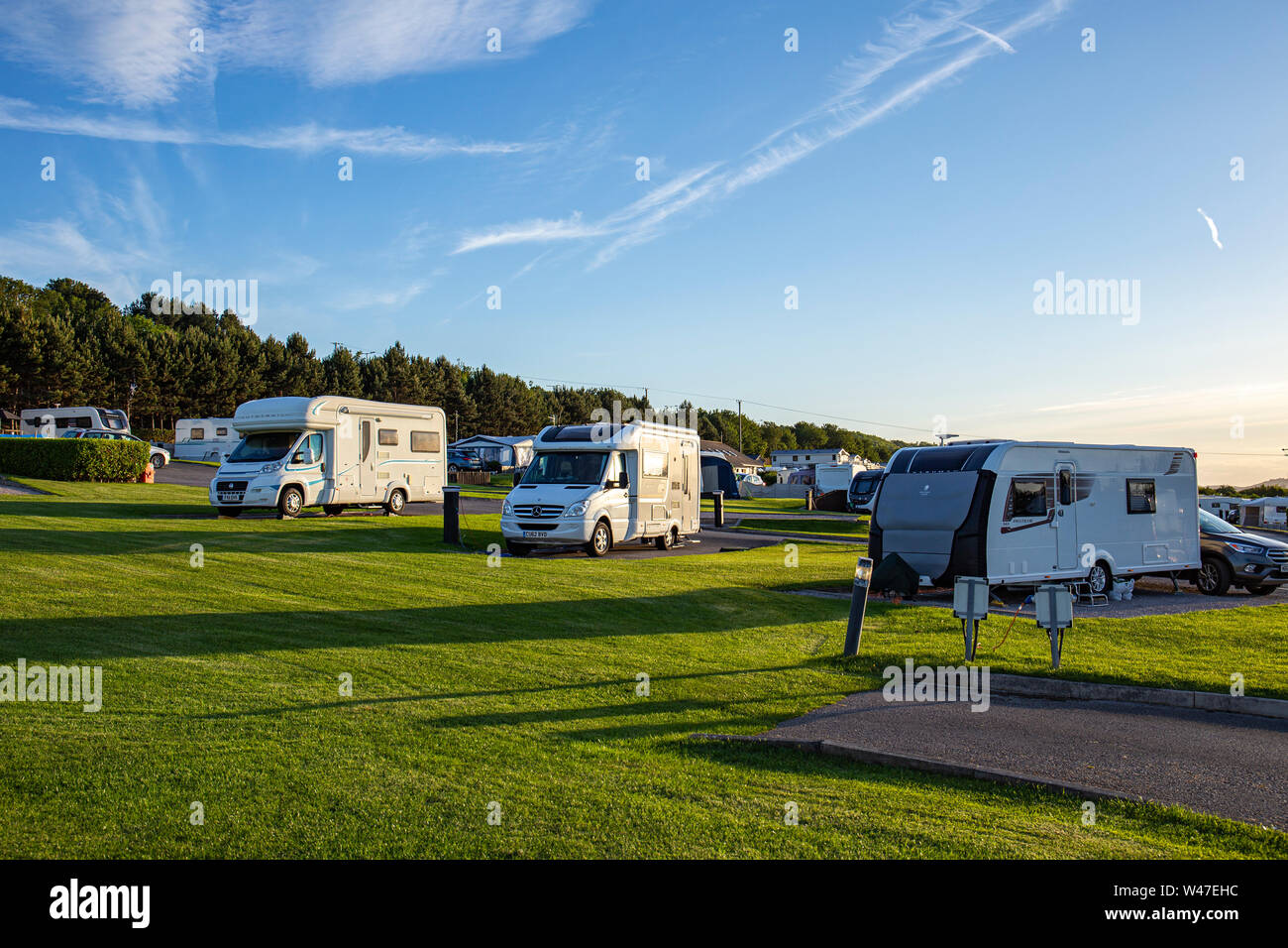 Late evening sun with camper vans and caravans on a campsite in North Wales UK Stock Photo