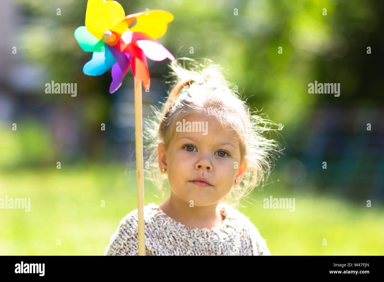 Child with Pinwheel in the summer park looking at camera Stock Photo ...
