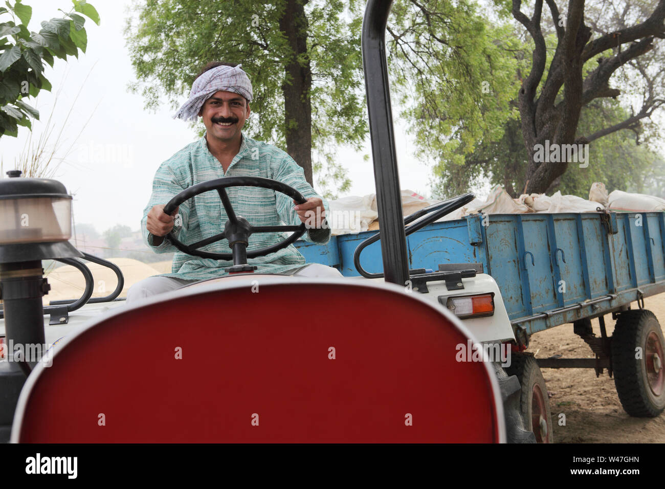 Indian farmer driving a tractor Stock Photo - Alamy