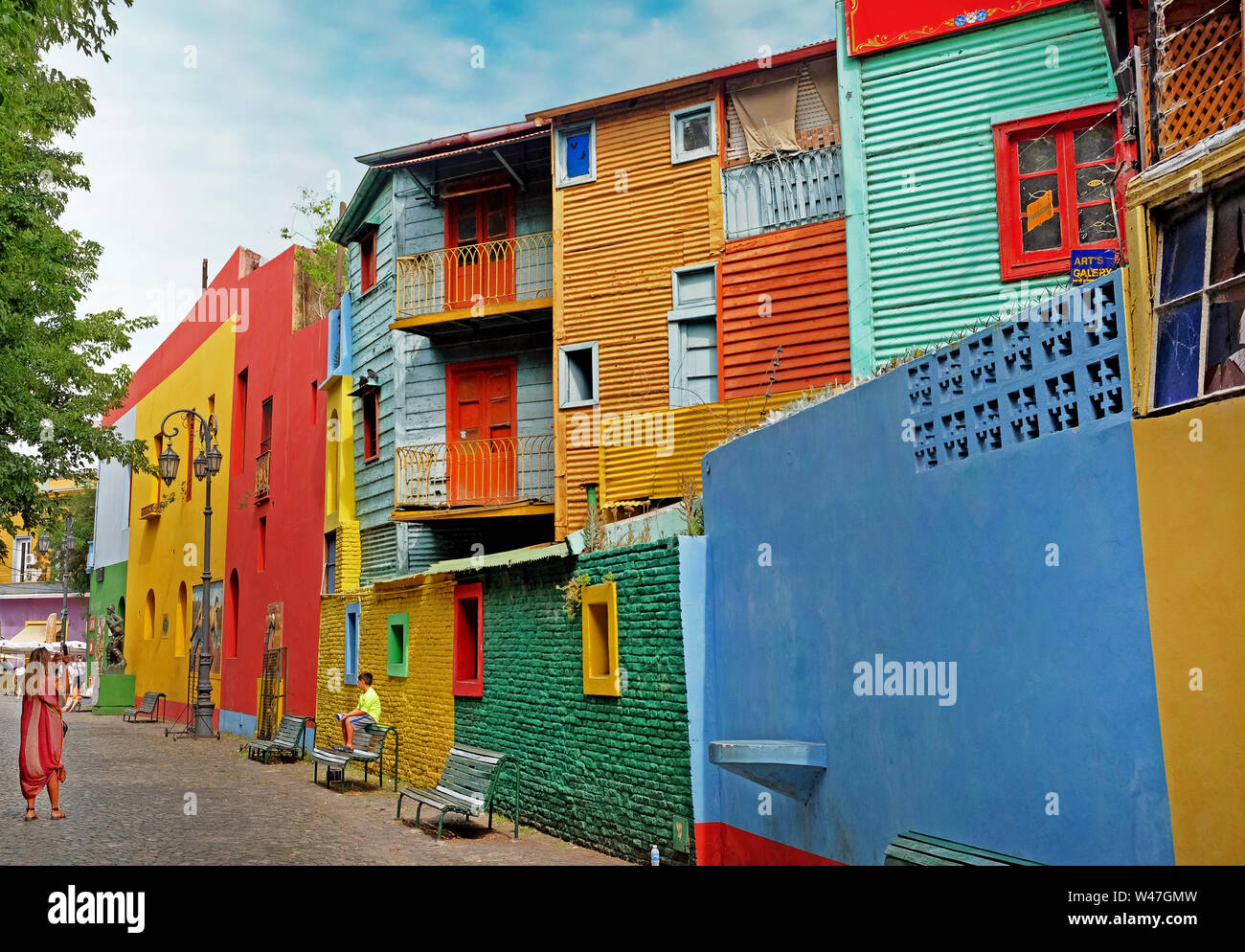 Woman photographing a child in front of colorful buildings of the Argentinean district La Boca, in Buenos Aires, during a summer day with a blue sky. Stock Photo