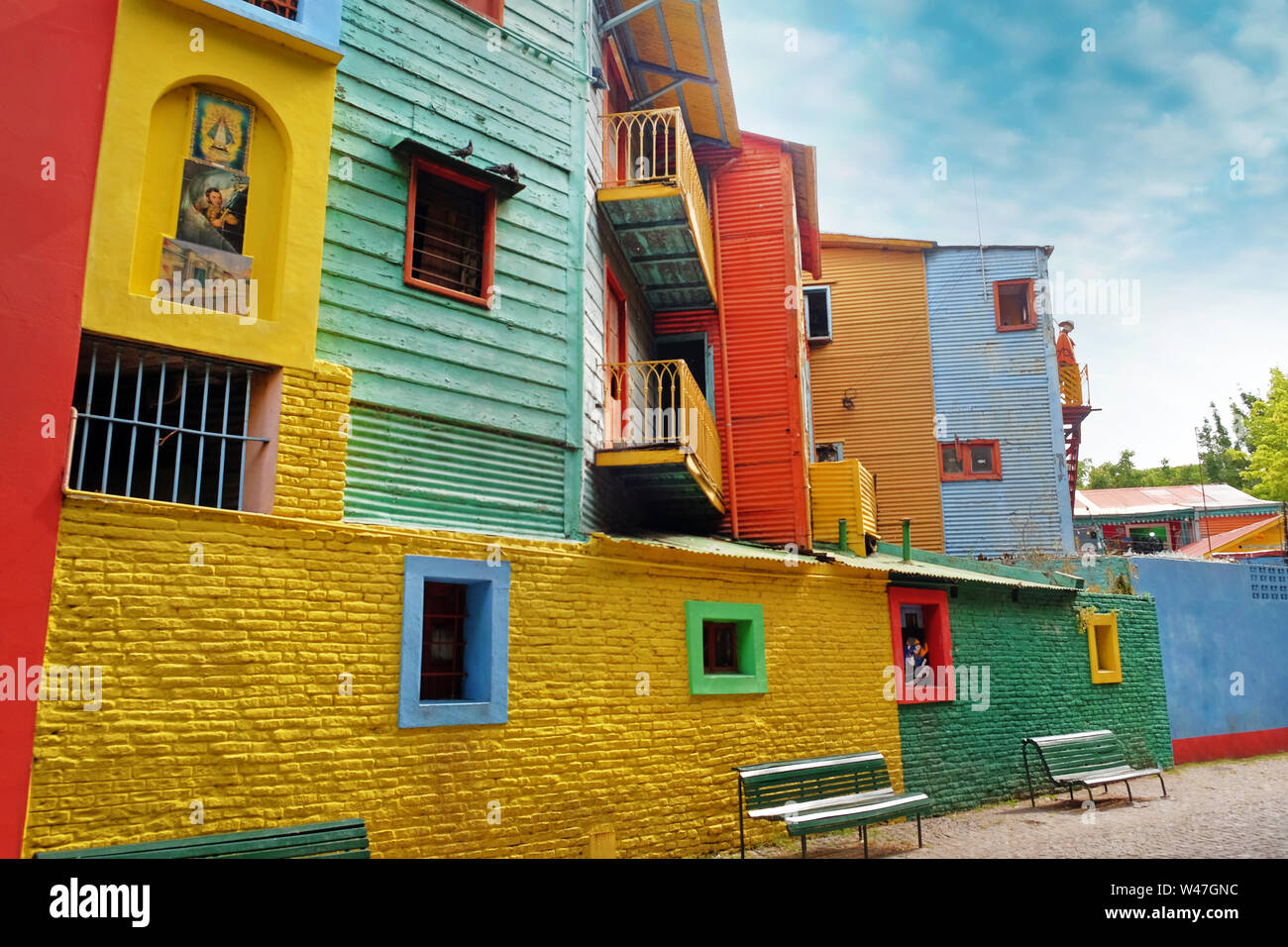 View of colorful buildings in Caminito of the Argentinean district La Boca, in Buenos Aires, with vintage walls against a blue sky. Stock Photo