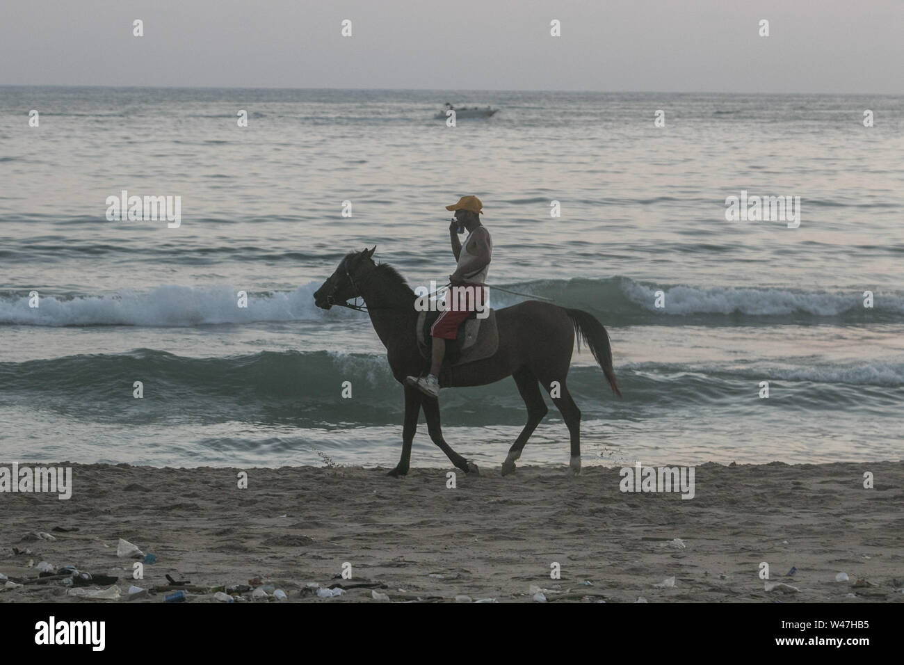 Beirut, Lebanon. 20th July, 2019. A man rides a horse at the beach as the sun sets in Beirut. Credit: Amer Ghazzal/SOPA Images/ZUMA Wire/Alamy Live News Stock Photo
