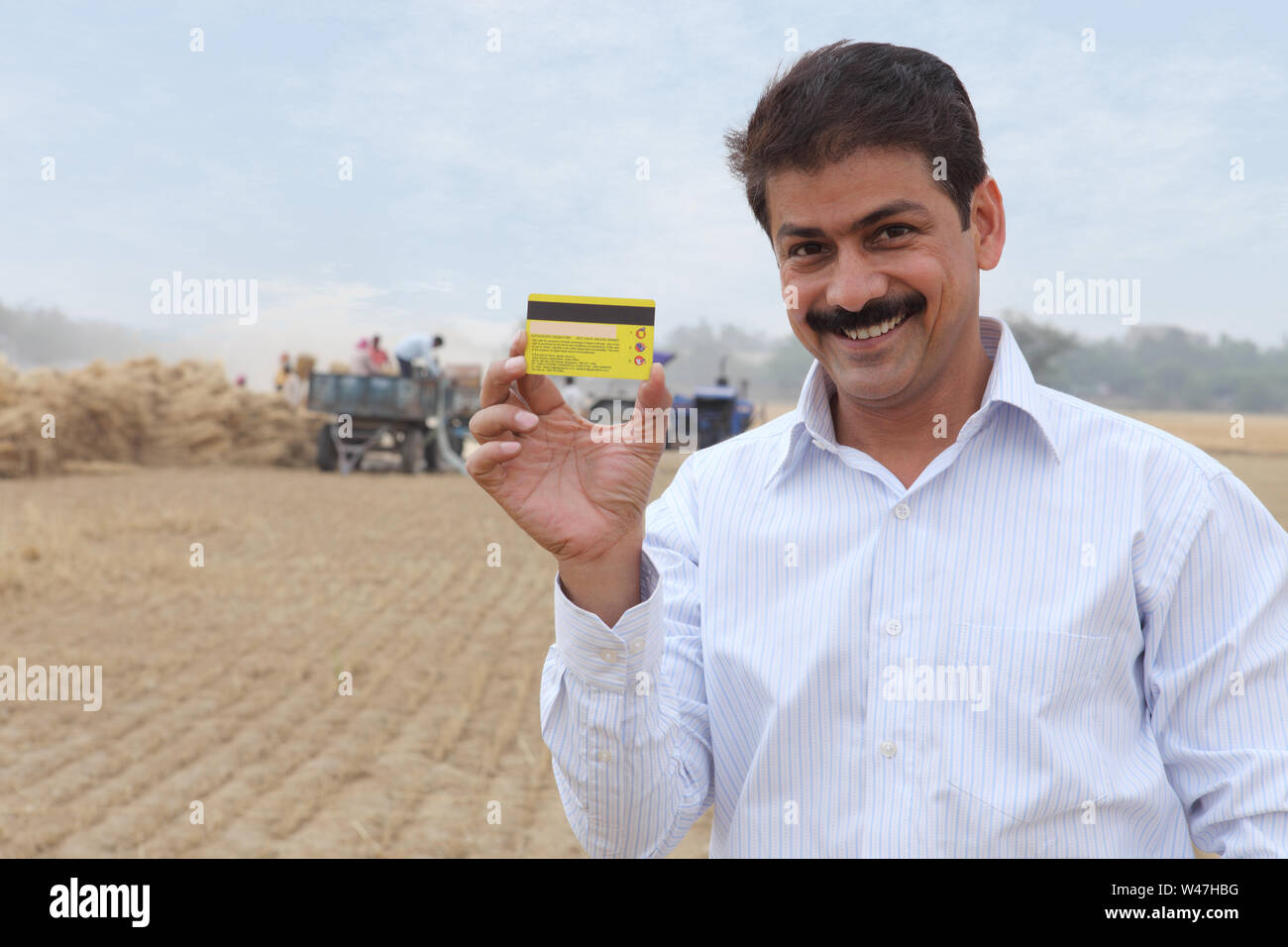 Indian businessman holding credit card and smiling Stock Photo - Alamy