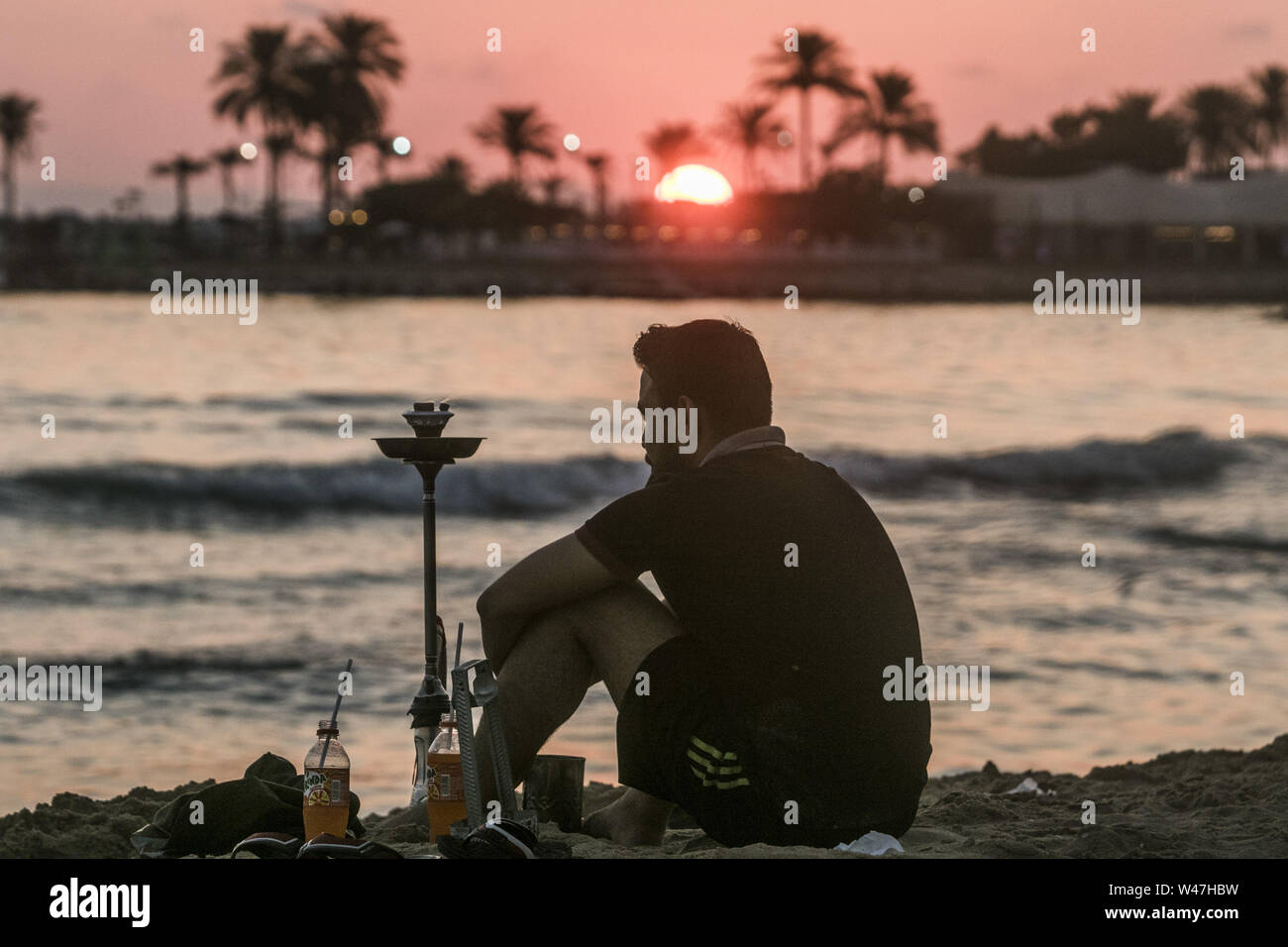 Beirut, Lebanon. 20th July, 2019. A man smokes a hukka pipe at the beach at sunset in Beirut. Credit: Amer Ghazzal/SOPA Images/ZUMA Wire/Alamy Live News Stock Photo