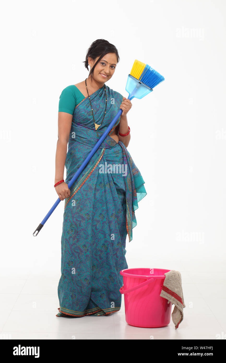 Woman holding broom and smiling Stock Photo Alamy